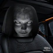 Close-up of a black car headrest cover with a grayscale horror-face print