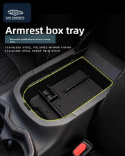 Black armrest box tray positioned inside the matching Toyota RAV4 console opening