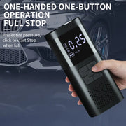 Cordless tire inflator held by hand near a parked car, showing one-button operation
