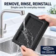 Removable black silicone armrest cover being rinsed under water for cleaning