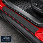 Black textured door sill protector shown on red vehicle door entry